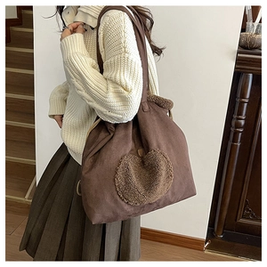 Detail of vintage brown suede tote bag with a soft lamb wool heart patch embroidery