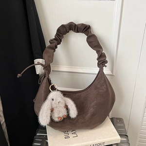 Detail of retro coffee PU leather crescent bag with scrunchie strap and rabbit charm