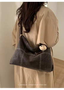Retro hobo shoulder bag with contrast stitching and plush bear charm on model