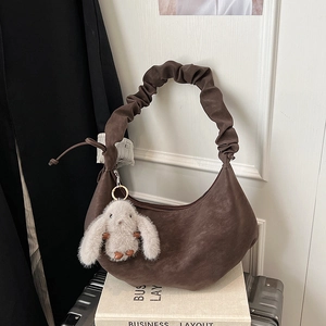 Detail of dark brown crescent bag with scrunchie handle and cute plush bunny charm
