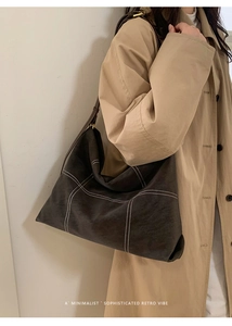 Detail of grey hobo bag with white contrast stitching and minimalist retro vibe