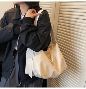 Fashionable cream white oversized soft leather tote bag on shoulder with pleat details
