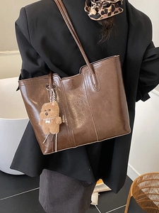 Brown oil wax leather tote bag for women with minimalist vertical stitching and bear charm