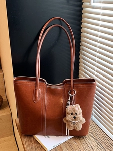 Brown vintage faux leather tote bag with contrast stitching and plush dog charm