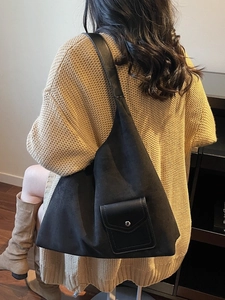 Grande borsa tote nera in pelle scamosciata con tasca frontale indossata da modella