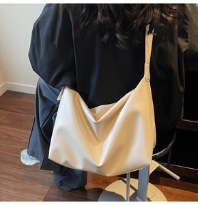 Detailed back view of a creamy white oversized crescent tote bag in soft matte PU leather