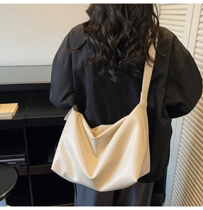 Model view of large cream-white tote bag showcasing practical capacity and shoulder strap