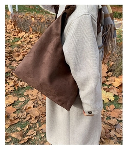 Detail of vintage dark brown suede tote bag with stylish knot design on shoulder strap
