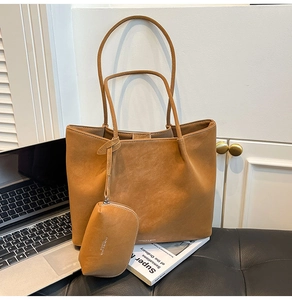Detail view of large brown tote bag with matte texture and matching zipper pouch