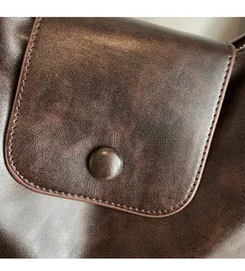 Detail of premium brown faux leather texture with stitching and button closure