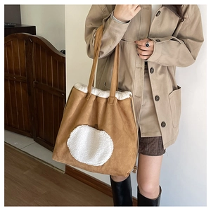 Detail of vintage brown suede tote bag featuring white fleece embroidery and trim