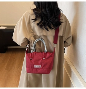 Vue arrière d'un mannequin portant un sac fourre-tout rouge avec poignée en corde