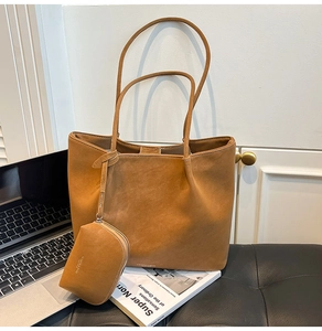Detail of a large brown matte tote bag with matching coin purse on an office chair