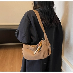 Brown nylon crescent bag with drawstring details and colorful beaded tassel charm