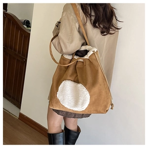Detailed side view of vintage suede tote bag with faux fur trim and drawstring closure