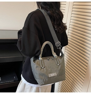 Détail du grand sac cabas gris avec poignées tressées colorées et bandoulière réglable