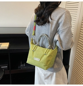 Détail du sac fourre-tout en nylon vert avec poignées tressées et texture tissée