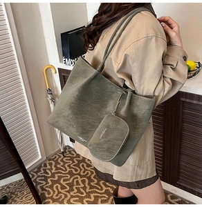 Detail shot of olive green leather tote bag with a hanging coin purse and dual straps