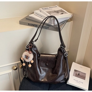 Detailed view of dark brown faux leather tote bag with a cute plush sheep charm