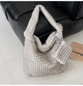Macro detail of plush grey faux fur tote bag with square texture and matching pouch