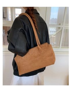 Makro-Seitenansicht einer großen braunen Wildleder-Tote-Bag zu einer schwarzen Lederjacke