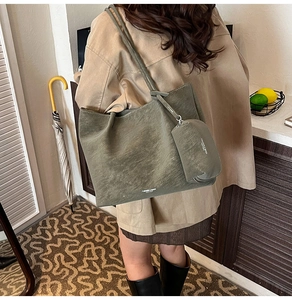 Detail of olive green tote bag with matte finish shown on shoulder in a warm lifestyle setting