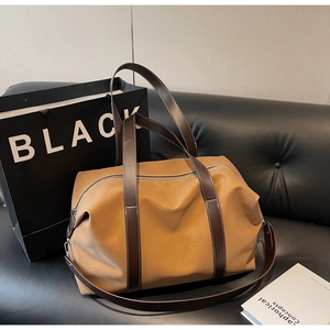 Close-up of minimalist large brown travel bag on leather sofa with vintage textures