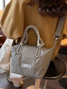 Sac bandoulière rétro en nylon gris-vert avec anses en corde tressée porté par un mannequin
