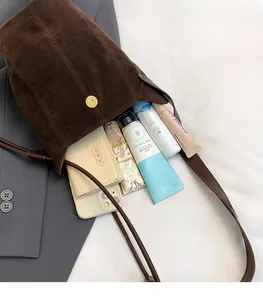 Interior view showing the large capacity of the brown suede bucket bag with daily items