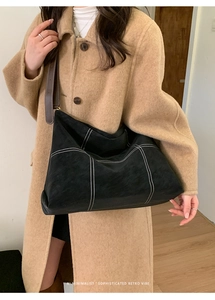 Minimalist black matte leather tote bag with white contrast stitching and brown straps