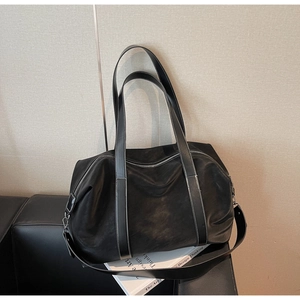 Detail of black large travel tote with white contrast stitching and dual carry handles