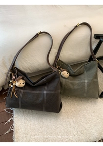 Detail of vintage tote bags with contrast stitching and plush bear charms in dark tones