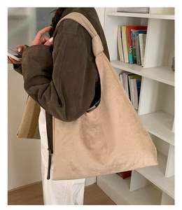 Detail of beige hobo tote bag featuring a knotted shoulder strap and soft matte texture