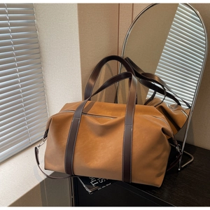 Detail of tan synthetic leather travel bag showing contrast stitching and silver zipper
