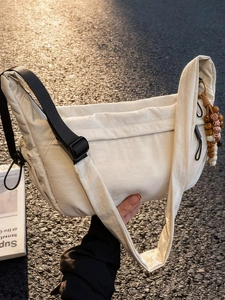 Minimalist beige nylon crescent bag with adjustable strap and bohemian bead charm