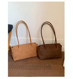 Nahaufnahme minimalistischer Tragetaschen aus mattiertem Wildleder in Camel und Dunkelbraun