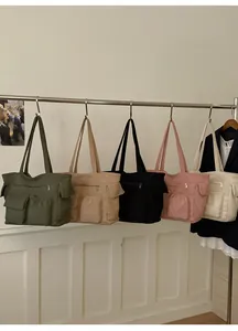 Detail of five corduroy tote bags in olive, khaki, black, pink, and beige colors