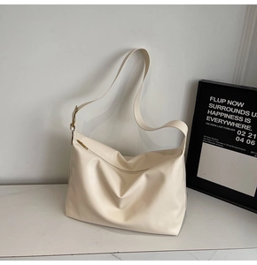 Detail of creamy white leather hobo tote with metal zipper and wide shoulder strap