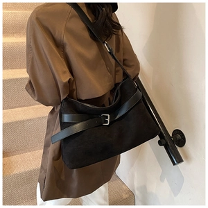 Détail du sac bandoulière noir mat avec boucle argentée et bandoulière sur modèle