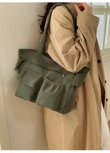 Detailed texture of forest green corduroy shoulder bag with multi-pocket design features