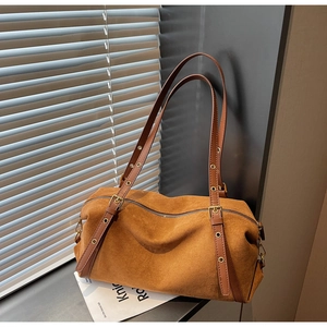 Detail of caramel frosted suede Boston bag texture and adjustable leather strap buckle