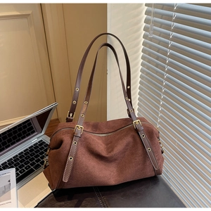 Detailed view of dark brown frosted suede bag featuring gold eyelet adjustable straps