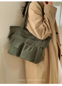 Dark green corduroy tote bag detail showing large front pockets and premium texture