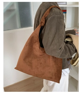 Detail view of brown suede hobo bag featuring a unique knotted shoulder strap design