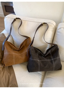 Detail of vintage matte hobo bags in tan and dark coffee with contrast stitching