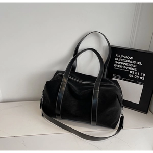 Detail of black large tote bag featuring white contrast stitching and dual leather straps