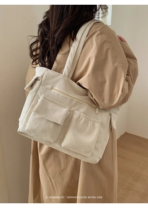 Close-up of beige corduroy tote bag showing textured fabric and external front pockets