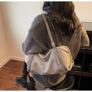 Detail view of the gray frosted texture shoulder bag with adjustable strap and rivet accents