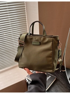 Olive green nylon crossbody bucket bag with adjustable wide strap and top handle
