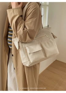 Close-up of beige corduroy tote bag with dual front flap pockets and zipper closure